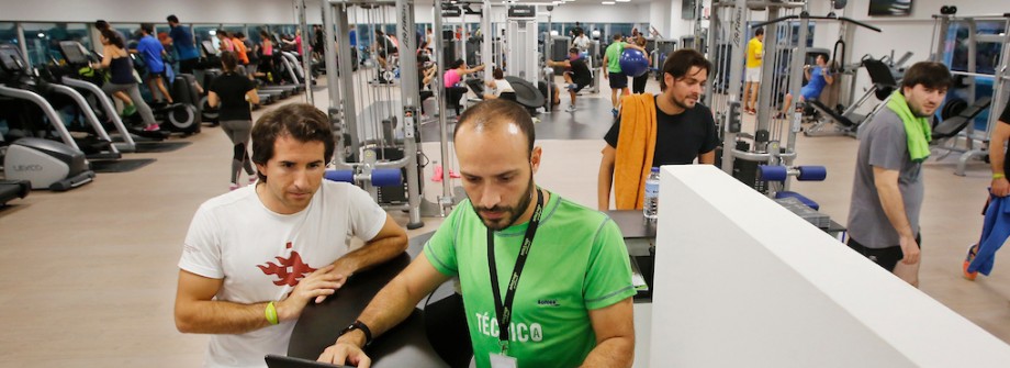 Técnico de sala fitness atendiendo a un usuario en un gimnasio de Vigo